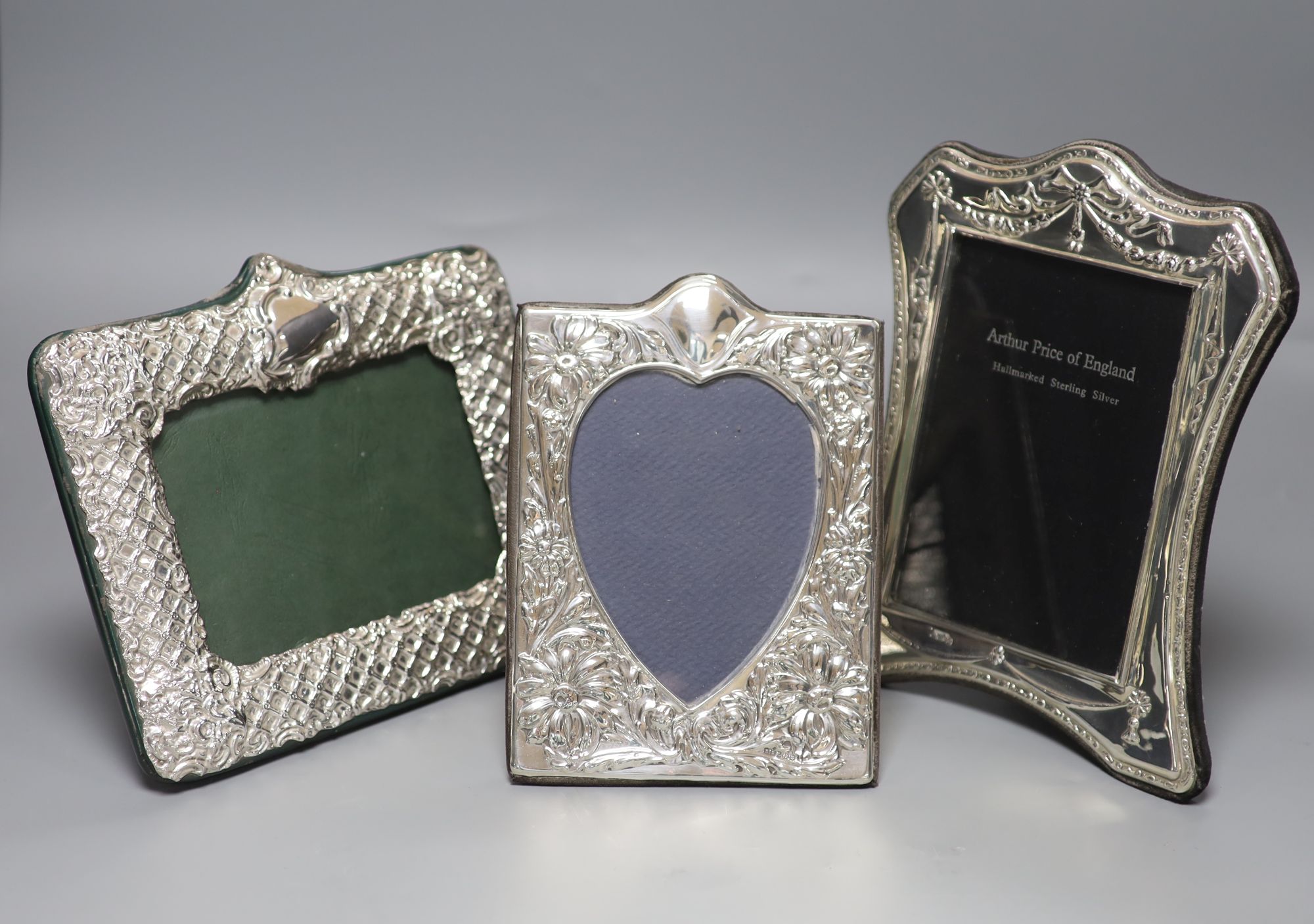 Three modern shaped and embossed silver easel photograph frames